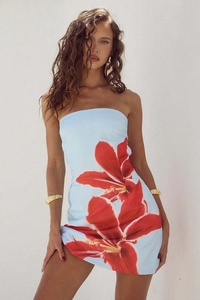 Detail of slim fit bodycon dress with large red lily floral print on light blue fabric