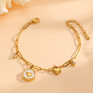 Detail of 18K gold paperclip chain bracelet with heart pendants and zircon stones