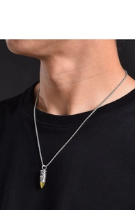 Close-up of vintage skull bullet pendant on a silver metal chain for men's fashion