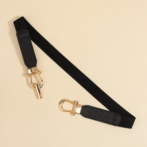 Detail of minimalist elastic waist belt with gold horseshoe buckle and black PU leather