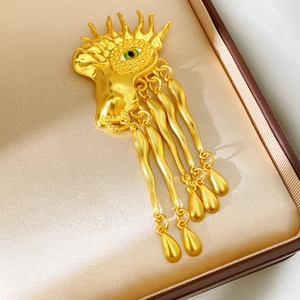 Detailed macro view of vintage eye brooch with gold tassels and green pupil detail