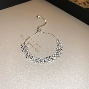 Close-up of a silver multi-layer V-shaped rhinestone bracelet with an adjustable bolo clasp