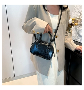 Polished black patent leather mini Boston bag worn with a casual grey blazer outfit