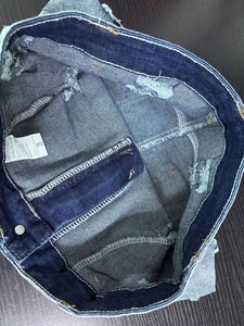 Vista dettagliata dell'etichetta di lavaggio e cuciture interne su shorts in denim
