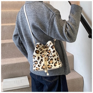 Detail of leopard print faux fur bucket bag with pearl drawstring and golden chain