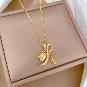 Detailed view of golden tulip pendant with zircon-studded moon and leaf on a titanium chain