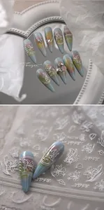 Detail von weißen 3D geprägten Kamelien- und Schmetterlings-Nagelstickern auf Mattbasis