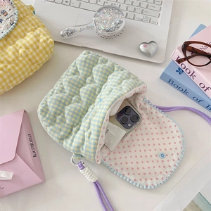 Detailed interior of heart quilted crossbody bag with dot lining and snap closure