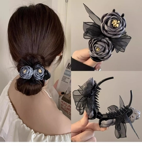 Detail of elegant black floral hair claw with lace and satin petals for bun hairstyles