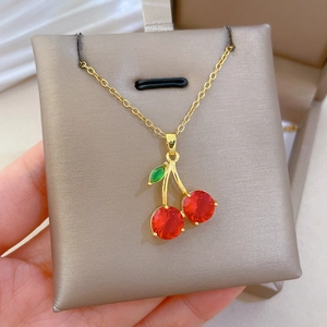 Détail d'un collier cerise plaqué or avec cristaux étincelants rouges et verts
