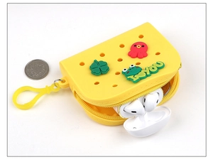 Detail of yellow silicone coin purse with cartoon charms for earbuds and small coins