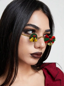 Detail of Christmas Y2K sunglasses with gold frame, red bow, and festive bell accents