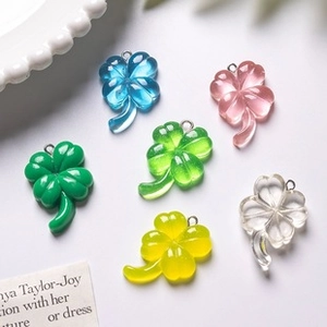 Macro shot of colorful resin four-leaf clover charms in blue pink green and yellow