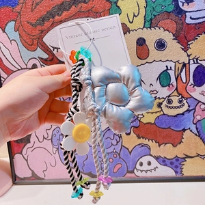 Gros plan d'un porte-clés en corde tressée avec étoile argentée et perles colorées