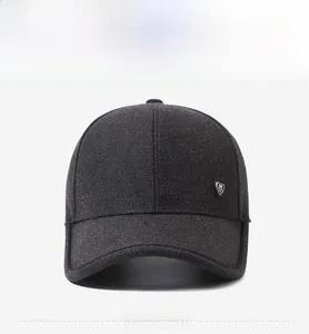 Detail of grey knitted baseball cap featuring a shield-shaped metallic M logo