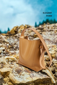 Nahaufnahme der hellbraunen Leder-Beuteltasche mit feinen Nähten auf Felsen im Freien