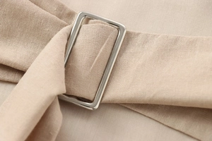 Détail macro de la sangle en tissu beige avec boucle de réglage rectangulaire argentée