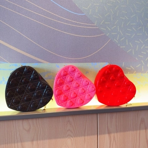 Fashionable heart-shaped crossbody bags in black, pink, and red with quilted textures