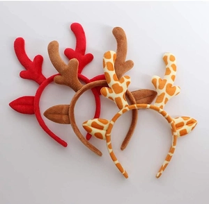 Detailed view of plush reindeer antlers and giraffe print headbands on white background