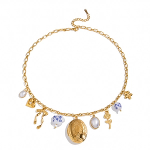 Detail van goudkleurige gelaagde ketting met medaillon, keramische bloem en parelhanger