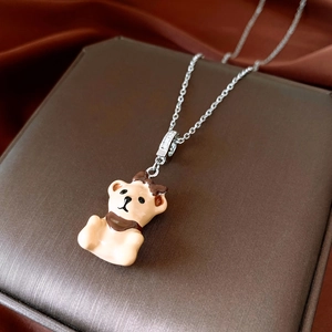 Close-up of adjustable silver bear pendant necklace with zircon inlay on jewelry box