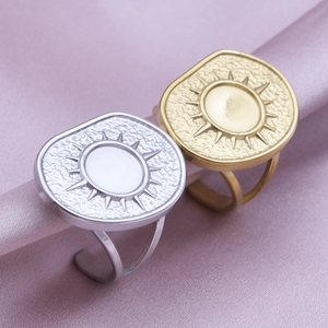 Detail of sun star engraved adjustable stainless steel rings in gold and silver