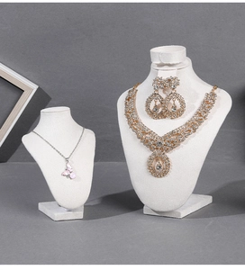 Detail of luxury velvet neck bust stand displaying a gold necklace and butterfly pendant