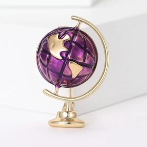 Exquisite gold-plated globe brooch featuring purple enamel inlay on a white background