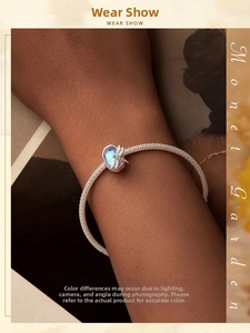 Macro shot of a silver mesh bracelet with an iridescent blue stone dragonfly charm