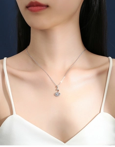 Close-up of elegant silver swan pendant necklace with bright zircons on a female model