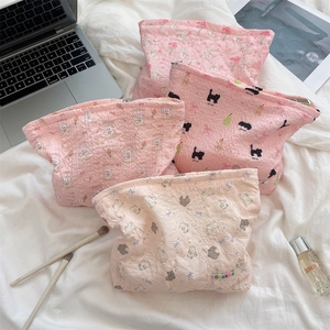 Detailed flat lay of pink quilted cotton makeup bags with cute cartoon floral patterns