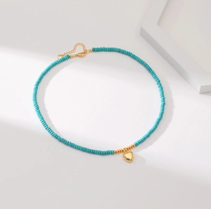 Handmade turquoise beaded necklace featuring a geometric gold heart pendant with clasp