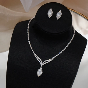 Close-up of bridal jewelry set with marquise-cut zircon necklace and stud earrings