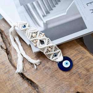Detail of handmade macrame Evil Eye wall hanging with blue glass and wooden beads