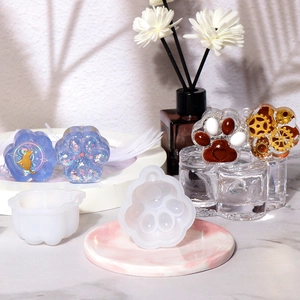 Detailed view of cat paw silicone molds with resin finished products on marble tray