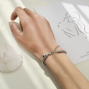 Detailed view of silver stainless steel chain bracelet on wrist with a lobster clasp