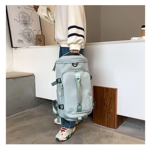 Detail view of mint green nylon travel bag with adjustable straps and sturdy top handle