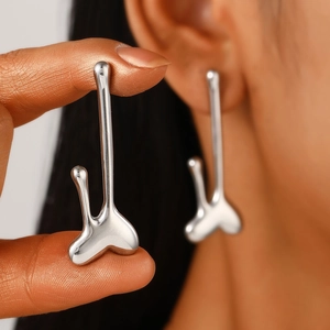Macro shot of silver liquid metal heart earrings featuring a modern abstract wavy design
