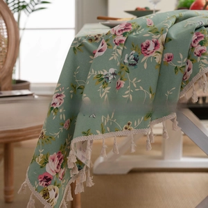 Detailed macro of vintage green floral table cloth with elegant white tassel trim decor