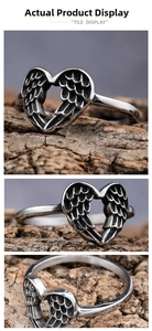 Macro detail of vintage silver angel wing ring showing heart shape and engraved feathers
