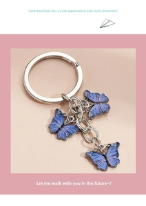 Detail of blue enamel butterfly pendants on a silver metal keychain for bags