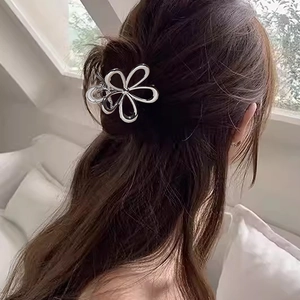 Pince à cheveux fleur évidée en métal argenté portée par un mannequin aux cheveux bruns