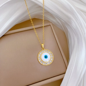 Gold titanium steel necklace with blue evil eye pendant and crystal halo on jewelry box
