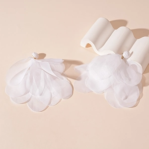 Detail of layered white fabric petal earrings with resin rose bud and gold accents