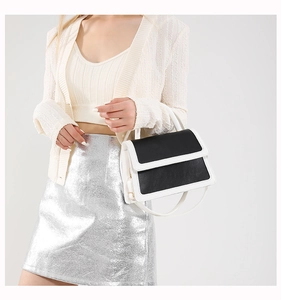 Detail showing the black and white leather contrast stitching on the luxury handbag