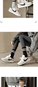 Detail view of black cotton crew socks with white double stripes on a model