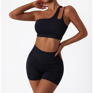 Détail de la brassière de sport asymétrique noire et du short à poches latérales