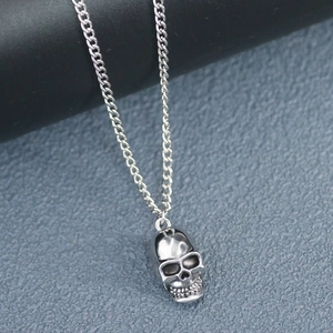 Detailed view of a silver skull pendant necklace with a polished metal finish for men