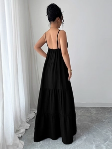 Back view of elegant black tiered maxi dress with thin straps and layered skirt design