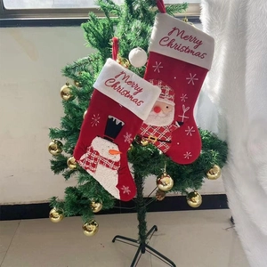 Classic red Christmas stockings with Santa and Snowman hanging on a decorated tree